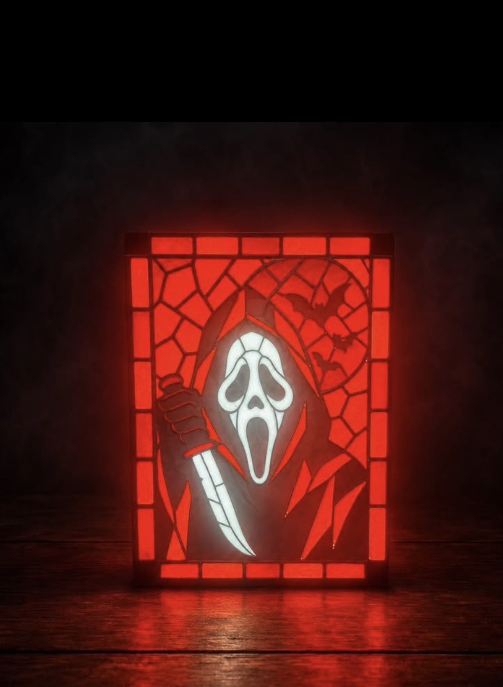 Red Ghostface portrait with geometric border and bats displayed in a black light-up frame
