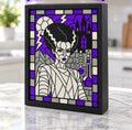 Bride of Frankenstein portrait with purple, gray, white and black mosaic design displayed in a black light-up frame