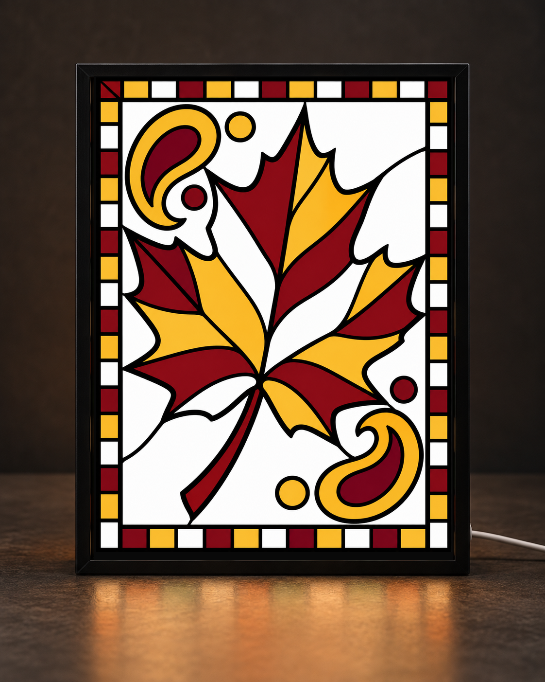 Illustrative framed preview of golden maple leaf surrounded by burgundy bandana-style swirls in slim black tabletop frame