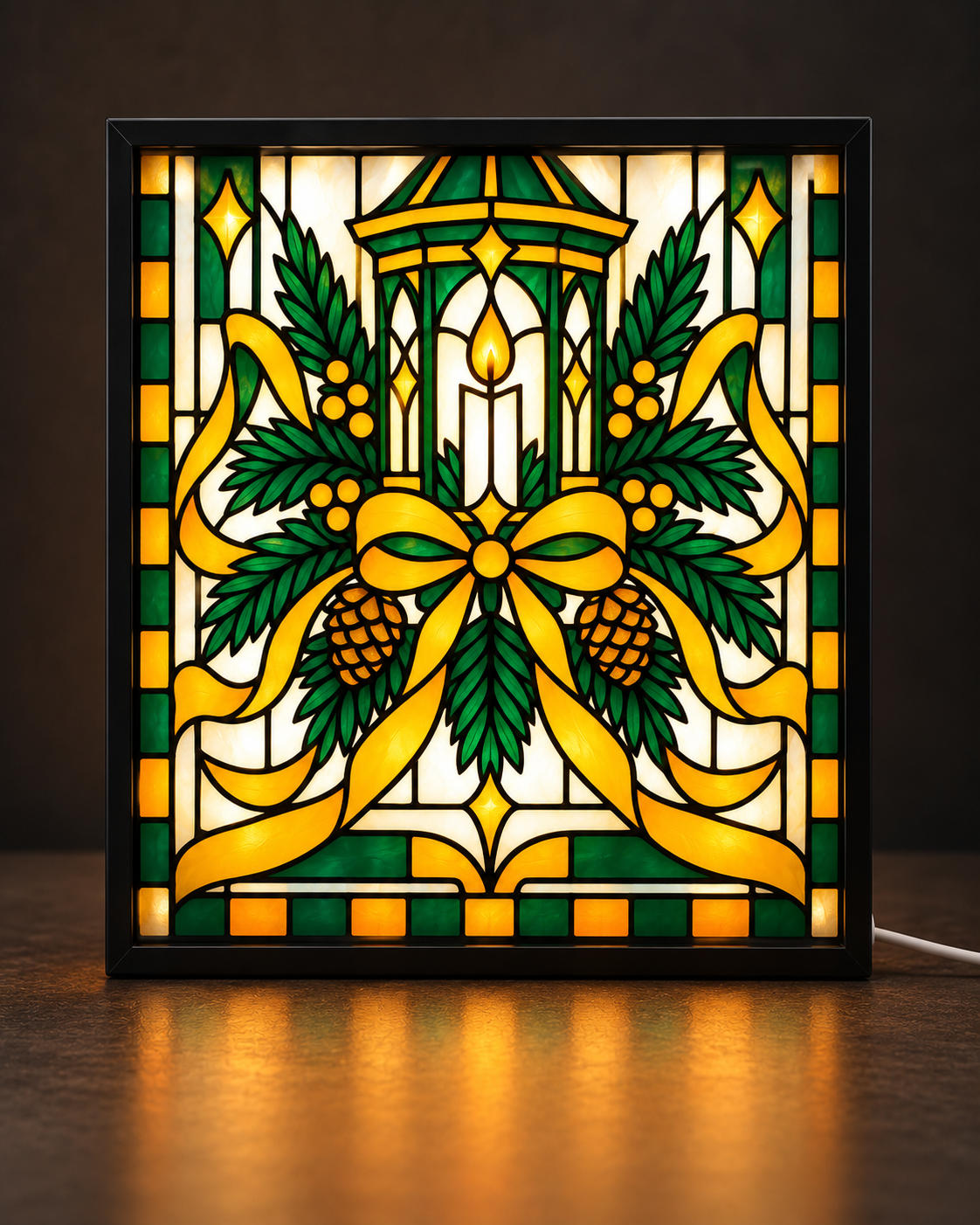 Illustrative framed preview of a golden Christmas lantern candle surrounded by green evergreen sprigs, pinecones and a sweeping golden bow inside a slim black illuminated tabletop frame